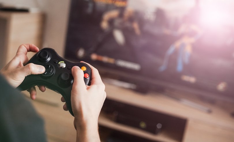 A person holding a video game remote and playing video game