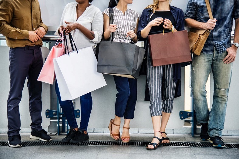 A group of people standing together and holding bags